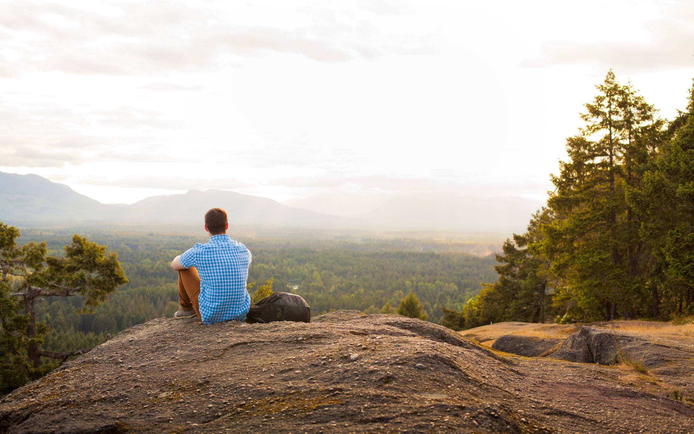 VIU Thrive student sitting on a hilltop
